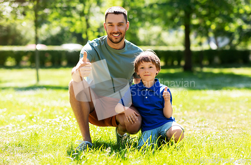 Image of happy smiling father and little son at summer park