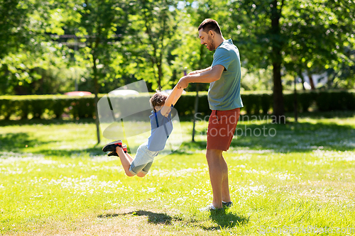 Image of happy father with son playing in summer park