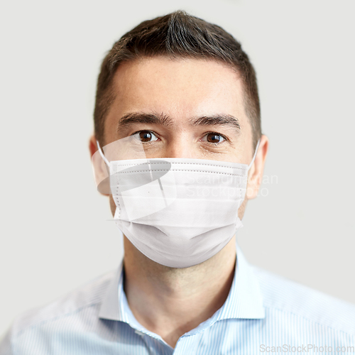 Image of businessman wearing face protective mask at office