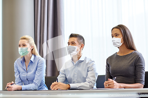 Image of group of business people in masks at office