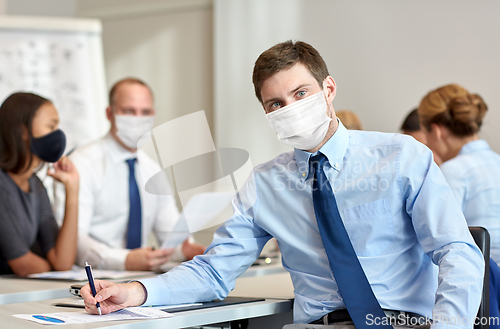 Image of businessman wearing face protective mask at office