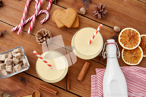 Image of glasses of eggnog, ingredients and spices on wood