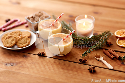 Image of glasses of eggnog, oatmeal cookies and fir branch