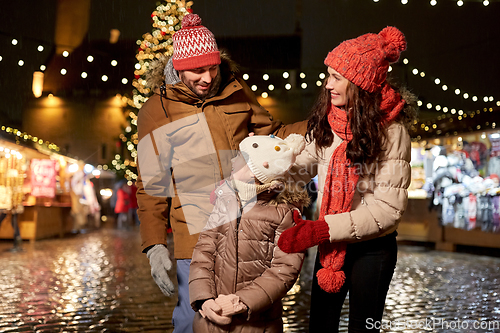 Image of happy family at christmas market in city