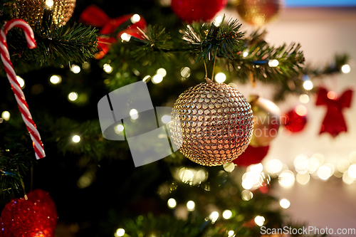 Image of golden christmas ball decoration on fir tree