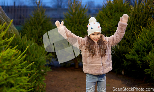 Image of little girl choosing christmas tree at market