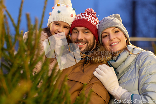Image of happy family choosing christmas tree at market