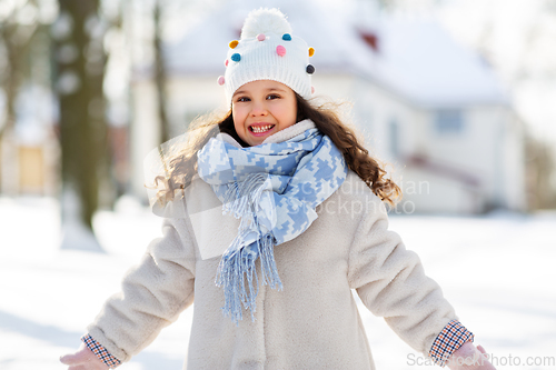 Image of happy little girl in winter clothes outdoors