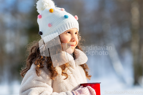 Image of little girl with cup of hot tea in winter park