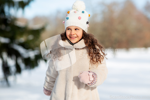 Image of happy little girl in winter clothes outdoors