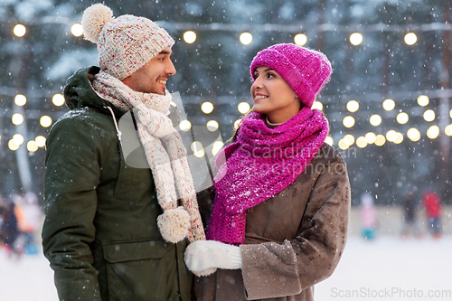 Image of happy couple at outdoor skating rink in winter