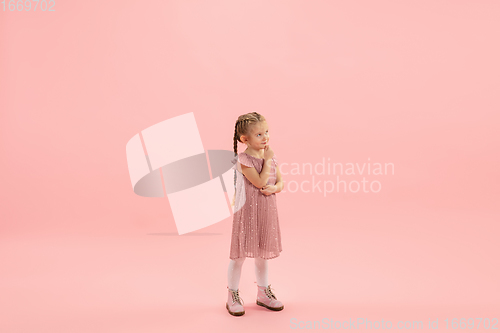 Image of Childhood and dream about big and famous future. Pretty longhair girl isolated on coral pink background