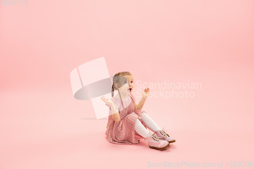 Image of Childhood and dream about big and famous future. Pretty longhair girl isolated on coral pink background