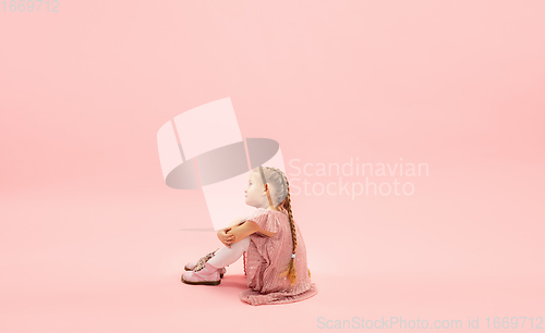 Image of Childhood and dream about big and famous future. Pretty longhair girl isolated on coral pink background