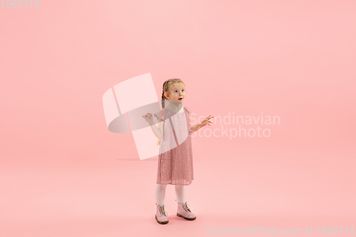 Image of Childhood and dream about big and famous future. Pretty longhair girl isolated on coral pink background