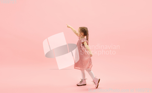 Image of Childhood and dream about big and famous future. Pretty longhair girl isolated on coral pink background