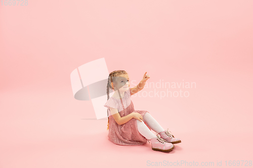 Image of Childhood and dream about big and famous future. Pretty longhair girl isolated on coral pink background