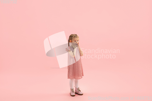 Image of Childhood and dream about big and famous future. Pretty longhair girl isolated on coral pink background