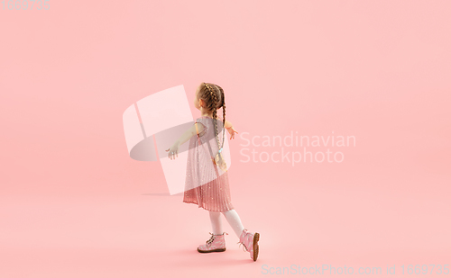 Image of Childhood and dream about big and famous future. Pretty longhair girl isolated on coral pink background