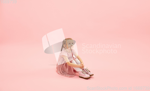 Image of Childhood and dream about big and famous future. Pretty longhair girl isolated on coral pink background