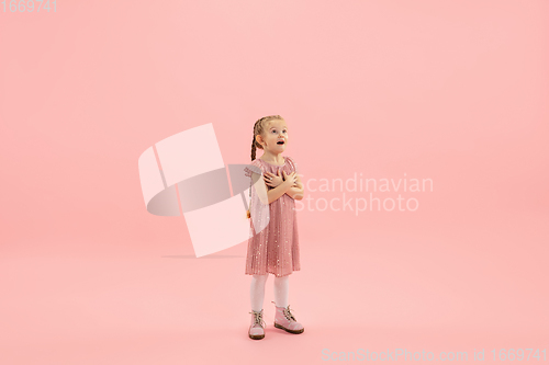 Image of Childhood and dream about big and famous future. Pretty longhair girl isolated on coral pink background