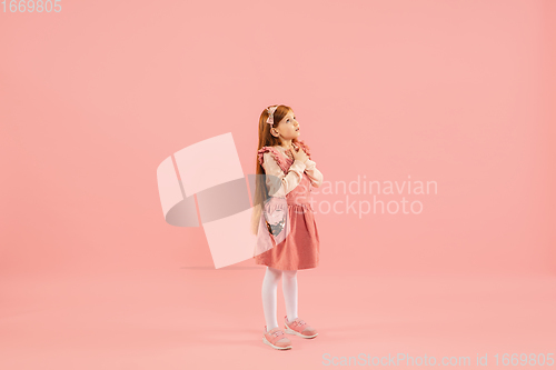 Image of Childhood and dream about big and famous future. Pretty longhair girl isolated on coral pink background