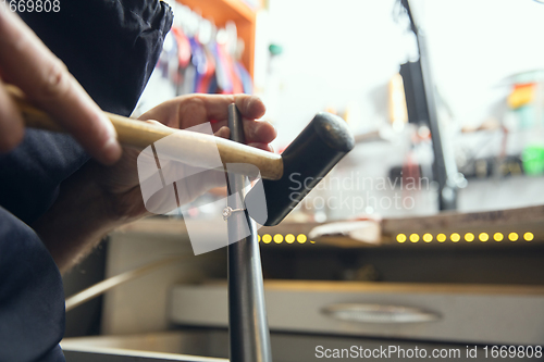 Image of Close up hands of jeweller, goldsmiths making of golden ring with gemstone using professional tools.