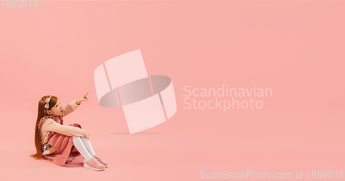 Image of Childhood and dream about big and famous future. Pretty longhair girl isolated on coral pink background