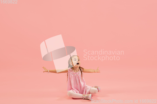 Image of Childhood and dream about big and famous future. Pretty longhair girl isolated on coral pink background