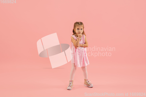 Image of Childhood and dream about big and famous future. Pretty longhair girl isolated on coral pink background