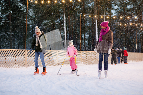 Image of happy family at outdoor skating rink in winter