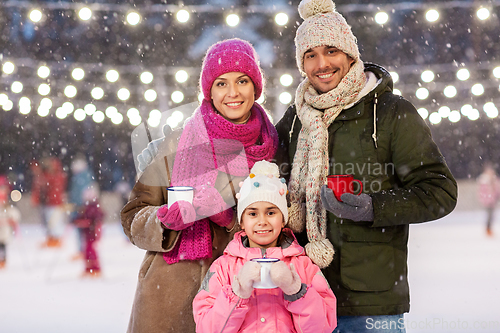 Image of happy family drinking hot tea on skating rink