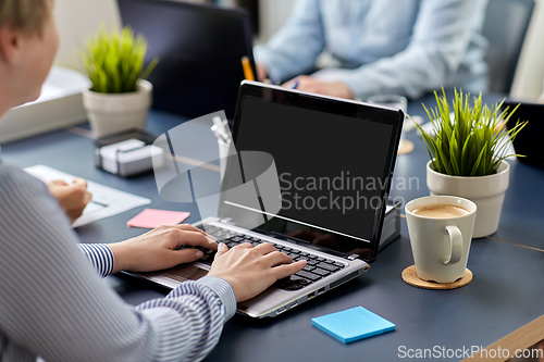 Image of businesswoman with laptop working at office