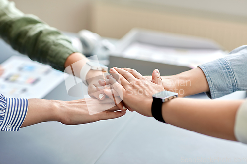 Image of close up of business team stacking hands