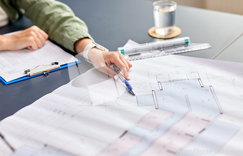 Image of architect with blueprint working at office