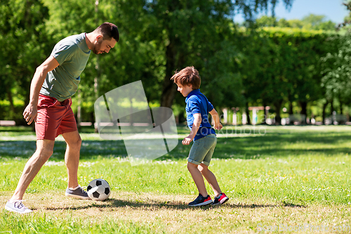 Image of father with little son playing soccer at park