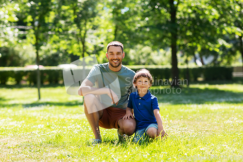 Image of happy smiling father and little son at summer park