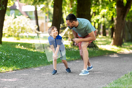 Image of happy father and son compete in running at park