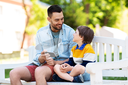 Image of father and son with smartphone at park