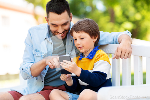 Image of father and son with smartphone at park