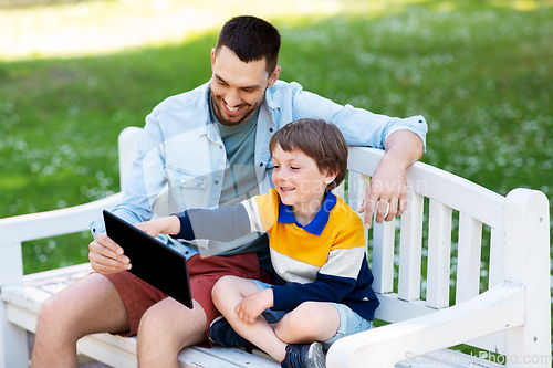 Image of father and son with tablet pc computer at park