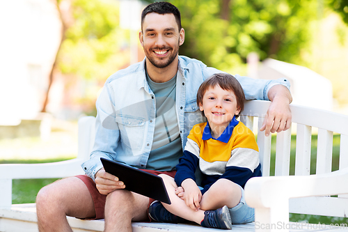 Image of father and son with tablet pc computer at park