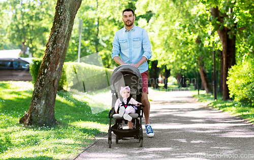 Image of happy father with child in stroller at summer park