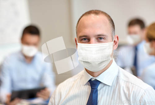 Image of businessman wearing face protective mask at office