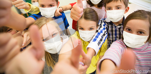 Image of group of children in masks showing thumbs up