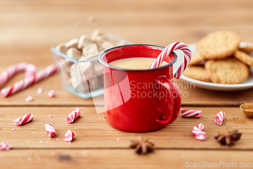 Image of cup of eggnog with candy cane, cookies and sugar