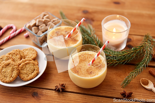 Image of glasses of eggnog, oatmeal cookies and fir branch