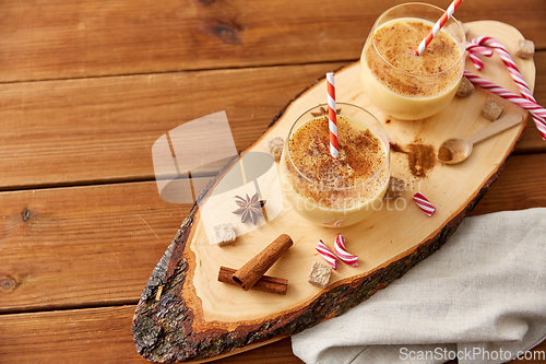 Image of glasses of eggnog, ingredients and spices on wood