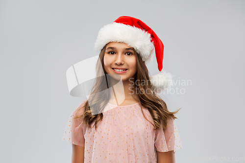 Image of happy teenage girl in santa hat on christmas