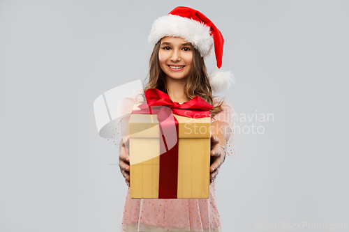 Image of teenage girl in santa hat with christmas gift